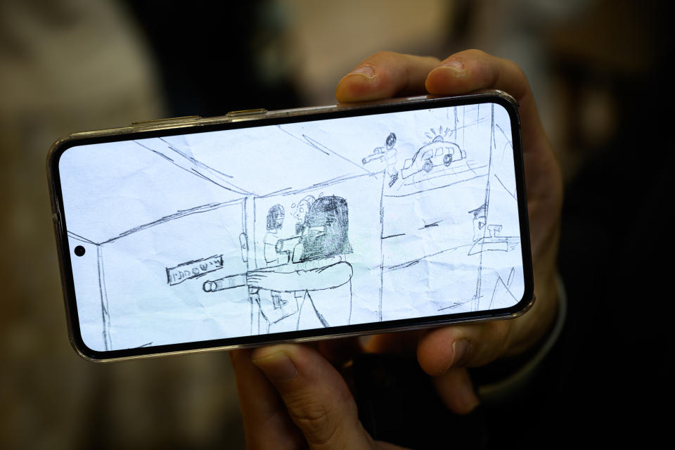 BNAI BRAK, ISRAEL - OCTOBER 22: A mobile phone screen displays a drawing by a young child showing the events he witnessed during the Hamas attack of 7/10, at Klil Malhchut Hall on October 22, 2023 in Bnai Brak, Israel. In this detail view, a man is shooting a house while sirens are heard in the distance. The centre has been opened by volunteers to provide food, clothing, entertainment and support for members of the ultra-Orthodox community of Netivot, who were forced to flee their homes following the attacks by Hamas on October 7, 2023. As Israel prepares to invade the Gaza Strip in its campaign to vanquish Hamas, the Palestinian militant group that launched a deadly attack in southern Israel on October 7th, worries are growing of a wider war with multiple fronts, including at the country's northern border with Lebanon. Countries have scrambled to evacuate their citizens from Israel, and Israel has begun relocating residents some communities on its northern border. Meanwhile, hundreds of thousands of residents of northern Gaza have fled to the southern part of the territory, following Israel's vow to launch a ground invasion. (Photo by Leon Neal/Getty Images)