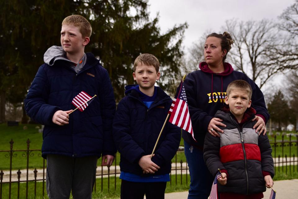 Macoy, Jordy, Crosby, and Kylee Winn watch a procession honoring Sgt. Jim Smith on April 11, 2021, in Independence.