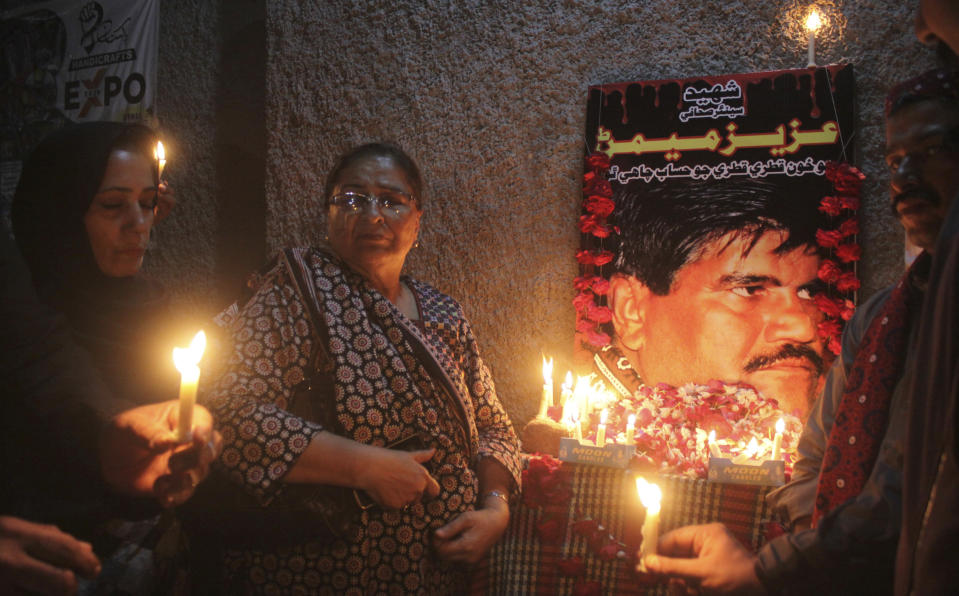 In this Oct. 17, 2020, photo, Pakistani civil society activists hold candle vigil to pay tribute to Aziz Memon in Hyderabad, Pakistan. In Pakistan, being a dissident or even raising a critical voice is dangerous business. Rights groups say that despite the election in 2018 of a civilian government, the army still rules from behind with an iron fist. (AP Photo/Pervez Masih)