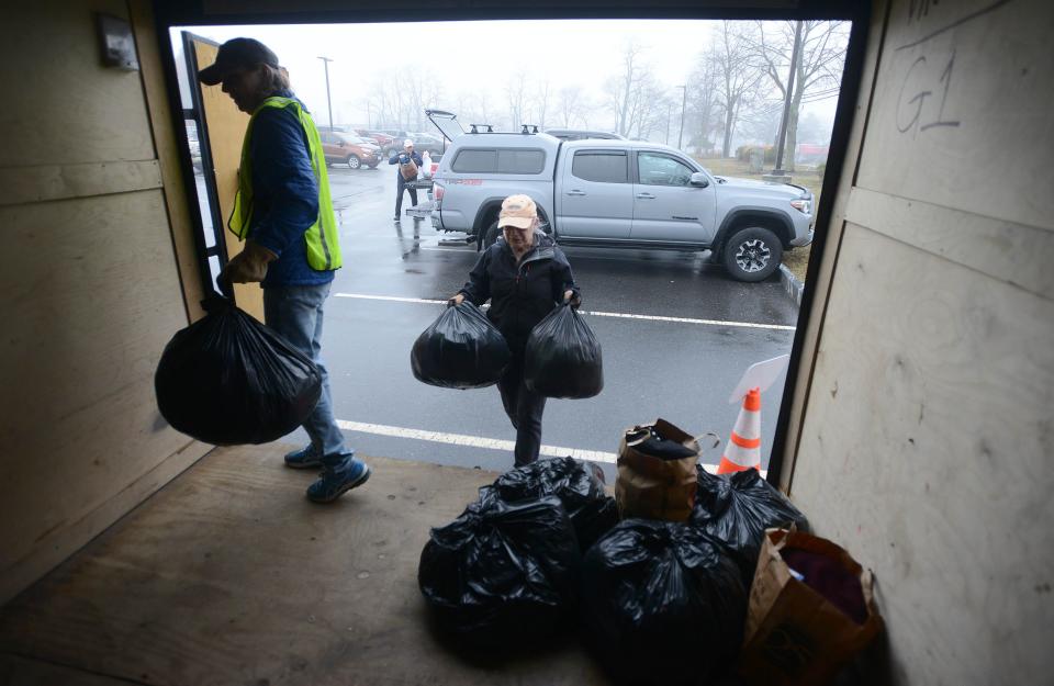Town of Falmouth's Recycling Coordinator Mary Ryther, left, helps Catherine Lafontaine as she drops off bags of clothing at a textiles recycling drop-off outside the Falmouth Senior Center earlier this month.