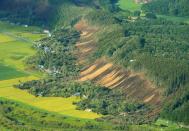 <p>This picture shows an aerial view of houses damaged by a landslide in Atsuma town, Hokkaido prefecture on Sept. 6, 2018, after an earthquake hit the northern Japanese island of Hokkaido. A powerful 6.6 magnitude quake hit the northern Japanese island of Hokkaido on Sept. 6, triggering landslides, bringing down several houses, and killing at least one person with several dozen missing. (Photo from Jiji Press/AFP/Getty Images) </p>