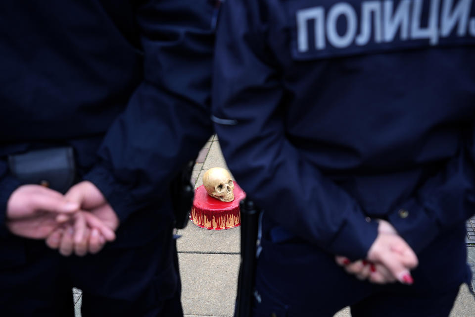 Serbian police officers stand by a cake with skull drop off in front of the Russian embassy building during a rally to mark the one-year anniversary of Russia's invasion of Ukraine in Belgrade, Serbia, Friday, Feb. 24, 2023. A traditional Slavic ally, Serbia has maintained friendly relations with Russia despite the invasion and has refused to join Western sanctions designed to punish Moscow for the aggression. (AP Photo/Darko Vojinovic)