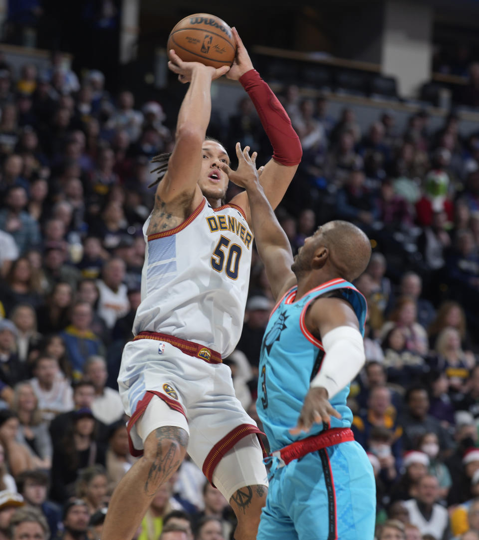 Denver Nuggets forward Aaron Gordon, left, shoots over Phoenix Suns guard Chris Paul in the first half of an NBA basketball game, Sunday, Dec. 25, 2022, in Denver. (AP Photo/David Zalubowski)