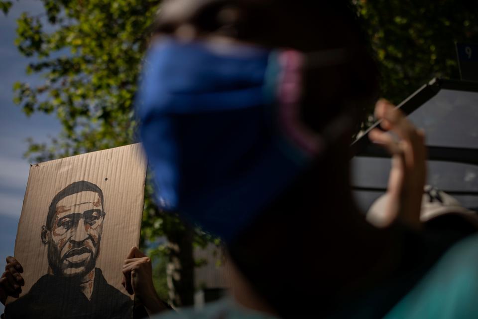 A demonstrator holds a George Floyd placard in front of the American embassy in Madrid on June 7, 2020, during a demonstration over the death of George Floyd and victims of racial injustice.