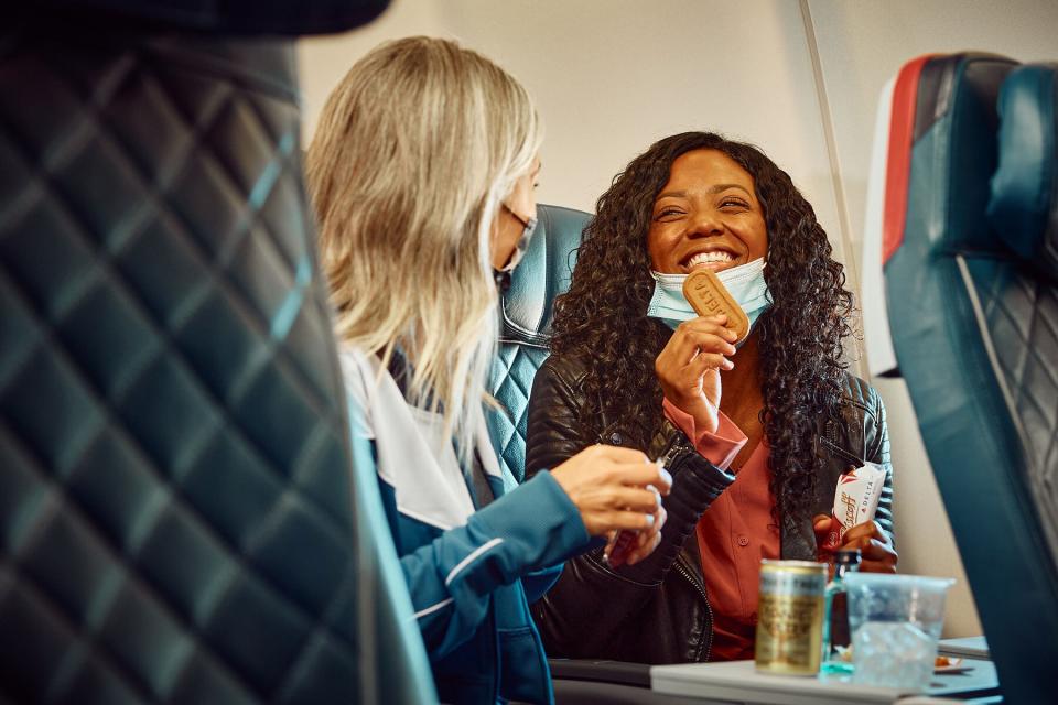 Two passengers eating the in flight Delta biscoff cookies