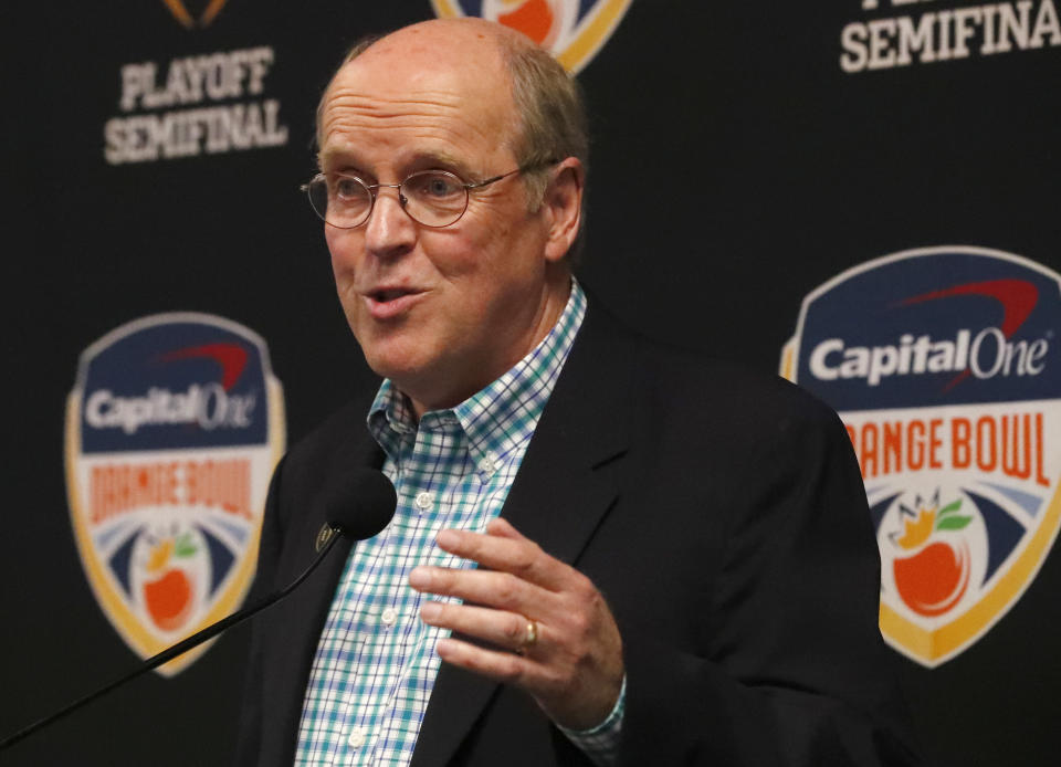 FILE - College Football Playoff executive director Bill Hancock gestures as he speaks during a news conference before an NCAA college football game between Miami and North Carolina in Miami Gardens, Fla., in this Thursday, Sept. 27, 2018, file photo. The CFP would expand from four to 12 teams, with six spots reserved for the highest ranked conference champions, under a proposal that will be considered next week by the league commissioners who manage the postseason system, a person familiar with announcement told The Associated Press on Thursday, June 10, 2021. The person spoke on condition of anonymity because the CFP has not yet released details. (AP Photo/Wilfredo Lee, File)