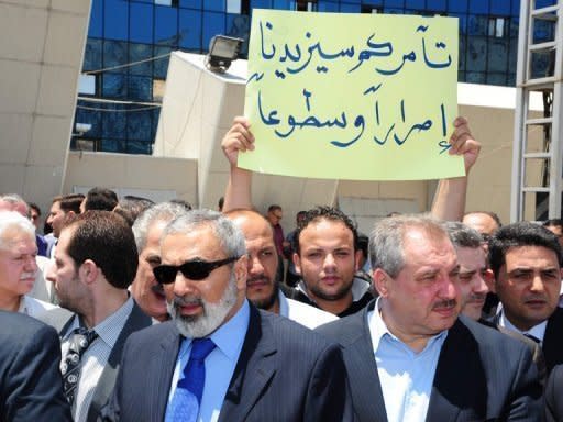 Picture from the official Syrian news agency SANA shows a demonstrator holding a sign which reads, "Your conspiracy will only make us more determined and bright" on June 27. Twin bombs exploded outside the Palace of Justice in Damascus on Thursday as deadly violence raged across the country and Turkey reinforced its volatile border with Syria with missile batteries