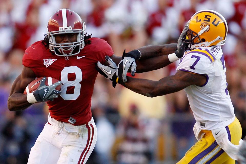 julio jones giving a stiff arm to an lsu player during a game