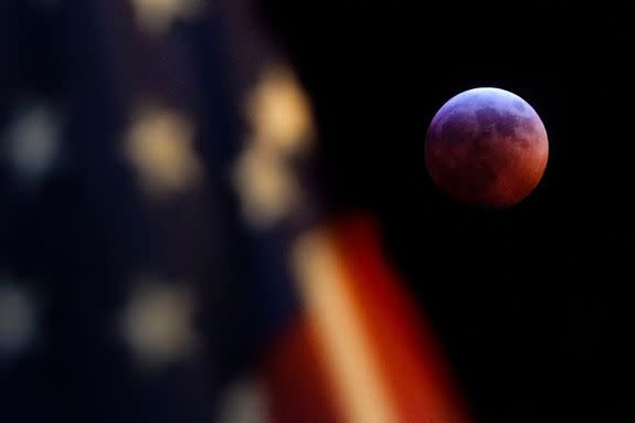 Mandatory Credit: Photo by J David Ake/AP/REX/Shutterstock (10069451a) A U.S. Flag in downtown Washington flies in front of the moon during a lunar eclipse, . The entire eclipse will exceed three hours. Totality - when the moon's completely bathed in Earth's shadow - will last an hour. Expect the eclipsed, or blood moon, to turn red from sunlight scattering off Earth's atmosphere Lunar Eclipse, Washington, USA - 20 Jan 2019