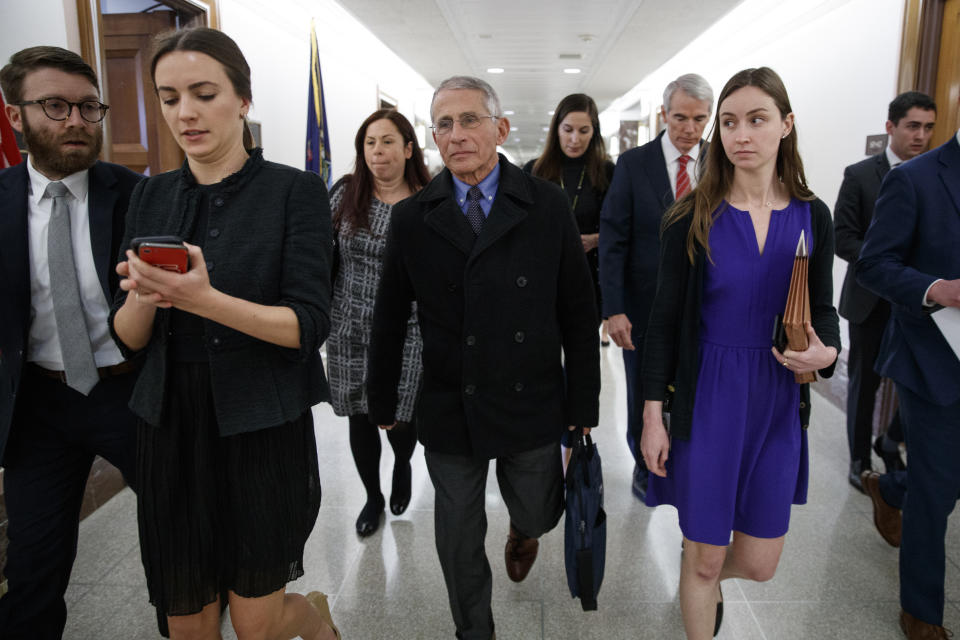 Dr. Anthony Fauci, director of the National Institute of Allergy and Infectious Diseases, fourth from left, walks with Sen. Rob Portman, R-Ohio, sixth from left, and others, to an elevator on Capitol Hill in Washington, Thursday, March, 12, 2020, after briefing members of Congress on the coronavirus outbreak. (AP Photo/Carolyn Kaster)