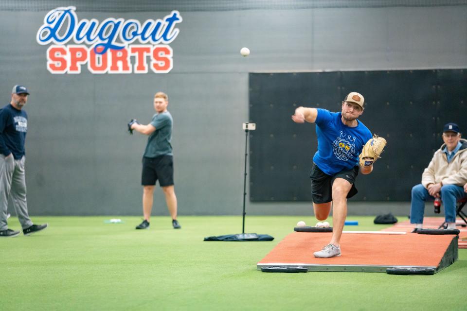C.J. Eldred, a pitcher in the minor leagues for the Kansas City Royals, throws a pitch at Dugout Sports in Fairfax on Jan. 24. Eldred's father, Cal, the former pitching coach for the Royals, watches along with Pittsburgh Pirates right-hander Mitch Keller.