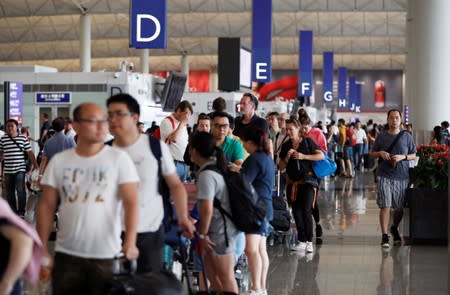 Passengers queue as the airport reopened a day after flights were halted due to a protest, at Hong Kong International Airport, China