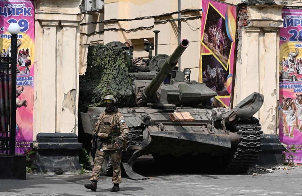 <div class="inline-image__caption"><p>A fighter of Wagner private mercenary group walks past a tank in a street near a local circus in the city of Rostov-on-Don, Russia.</p></div> <div class="inline-image__credit">Reuters</div>