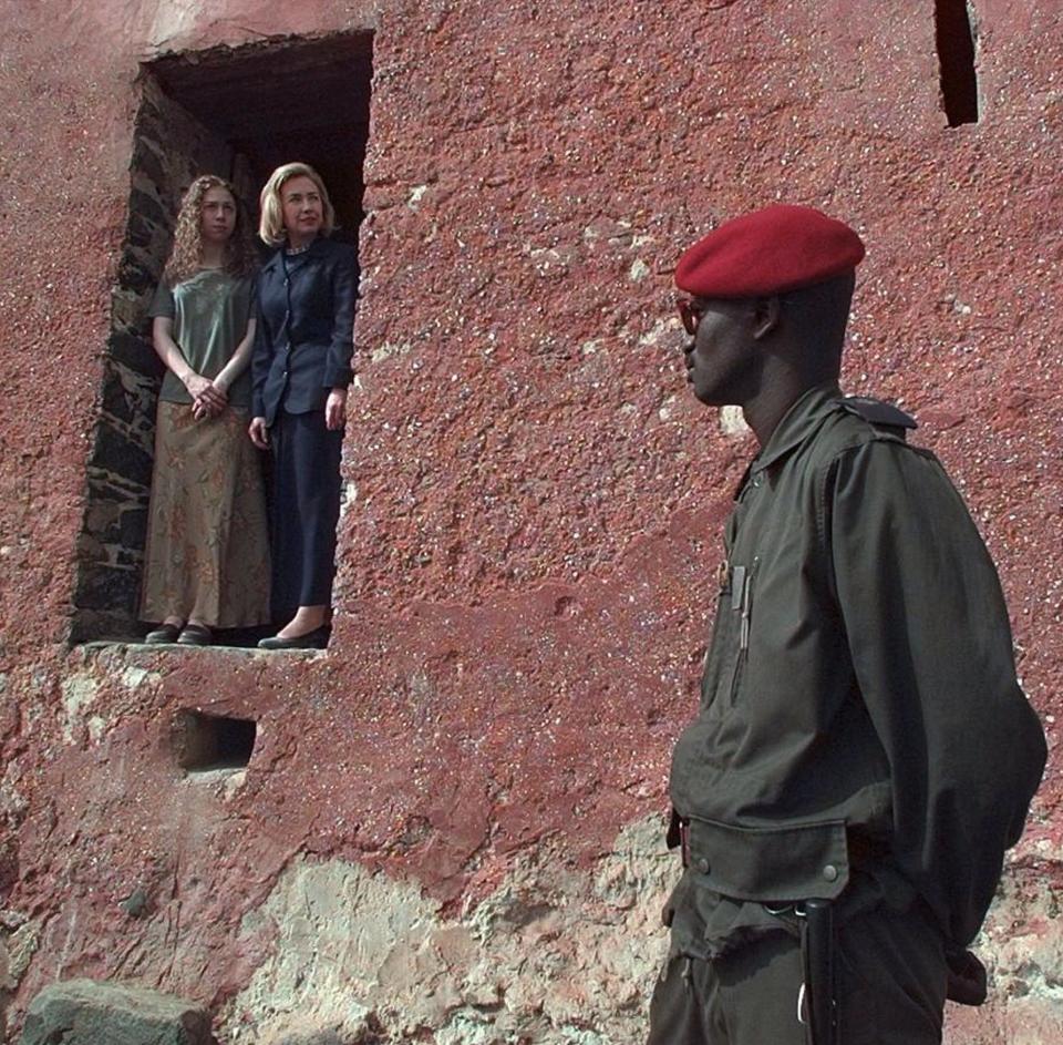 FILE - In this March 17, 1997, file photo, as a Senegalese guard looks on, first lady Hillary Rodham Clinton and daughter Chelsea look out from "the door of no return" on Goree Island in Dakar, Senegal. This is the door through which more than 60,000 slaves walked before being shipped to the west and used as slaves. Mrs. Clinton is on the first day of her two-week goodwill tour through Africa. When Melania Trump flies to Africa on her first extended international journey without the president, she’ll be following in the footsteps of her recent predecessors. (AP Photo/Doug Mills)