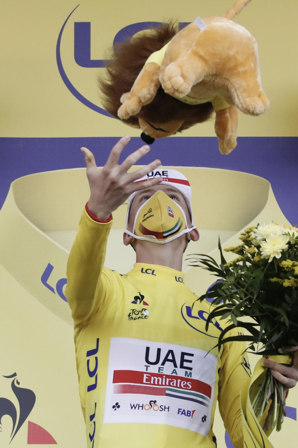 Stage winner and new overall leader, best young rider and best climber, Slovenia's Tadej Pogacar, wearing the yellow jersey, celebrates on the podium after stage 20 of the Tour de France cycling race, an individual time trial over 36.2 kilometers (22.5 miles), from Lure to La Planche des Belles Filles, France, Saturday, Sept. 19, 2020. (Sebastien Nogier/Pool via AP)