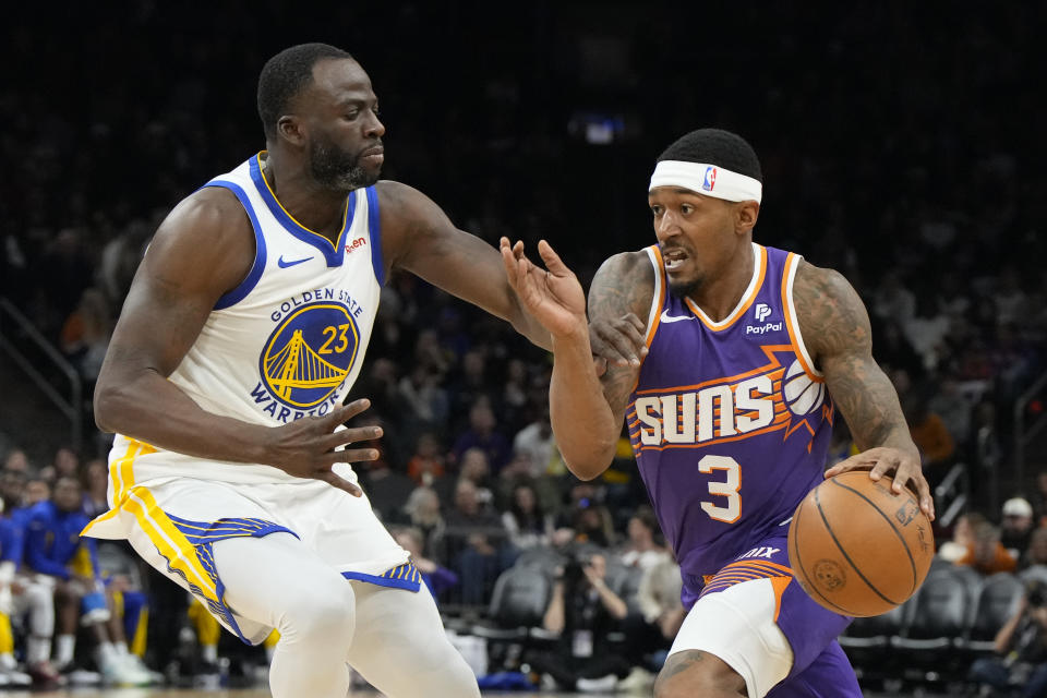 Phoenix Suns guard Bradley Beal (3) drives on Golden State Warriors forward Draymond Green (23) during the second half of an NBA basketball game, Tuesday, Dec. 12, 2023, in Phoenix. (AP Photo/Rick Scuteri)