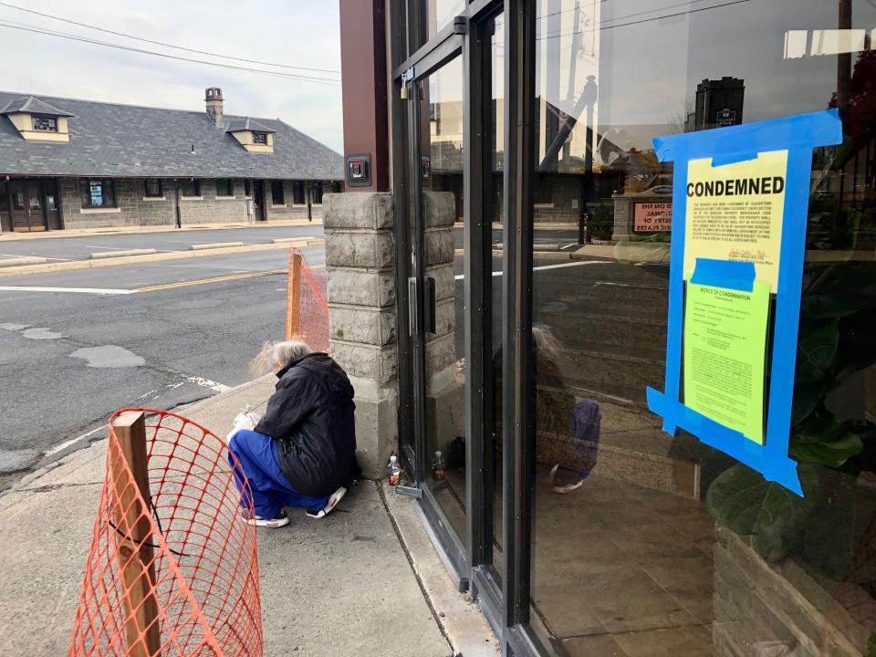 A resident of the Bush House Hotel sits outside the condemned building on Thursday. Despite efforts to find homes for residents who were displaced, some said they had nowhere else to go.