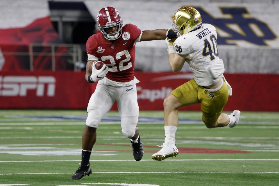 Alabama running back Najee Harris (22) runs the ball and fights off a tackle attempt by Notre Dame linebacker Drew White (40) in the second half of the Rose Bowl NCAA college football game in Arlington, Texas, Friday, Jan. 1, 2021. (AP Photo/Michael Ainsworth)