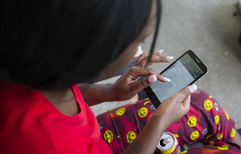 In this 2016 Tribune photo, Cassandra Mike looks for the free Wi-Fi signal at her home in South Bend. Tribune File Photo/Michael Caterina