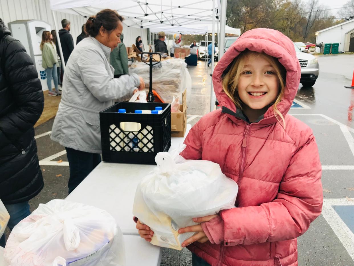 Volunteer Mikayla Luebker, 10, loads Thanksgiving goodies into cars at The Well Outreach in Spring Hill as volunteer drivers pick up and deliver food to families in need across Spring Hill and Columbia. The nonprofit provided almost 300 families with all of the makings for Thanksgiving dinner on Sunday.