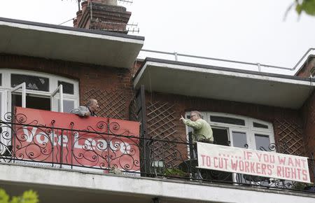Neighbours Tony (L) and Frank pose for cameras after hanging rival EU referendum banners from their balconies in north London, May 25, 2016. REUTERS/Neil Hall