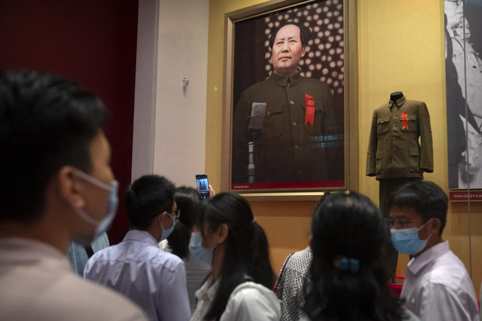 Visitors look at a display showing the suit Chinese leader Mao Zedong was wearing when he declared the establishment of the People's Republic of China at the newly-completed Museum of the Communist Party of China in Beijing, Friday, June 25, 2021. In the build-up to the July 1 anniversary, Chinese President Xi Jinping and the party have exhorted its members and the nation to remember the early days of struggle in the inland hills of Yan'an, where Mao Zedong emerged as party leader in the 1930s. (AP Photo/Mark Schiefelbein)