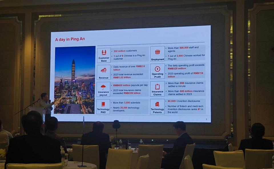 Dr. Xiao Jing, Chief Scientist of Ping An Group, presents his company's figures at the event 