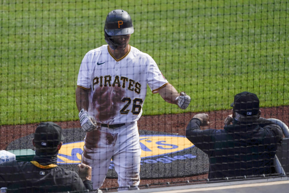 Pittsburgh Pirates' Adam Frazier (26) is greeted by teammates in the dugout after scoring from first on a double by Colin Moran in the first inning of a baseball game, Saturday, Aug. 22, 2020, in Pittsburgh. (AP Photo/Keith Srakocic)