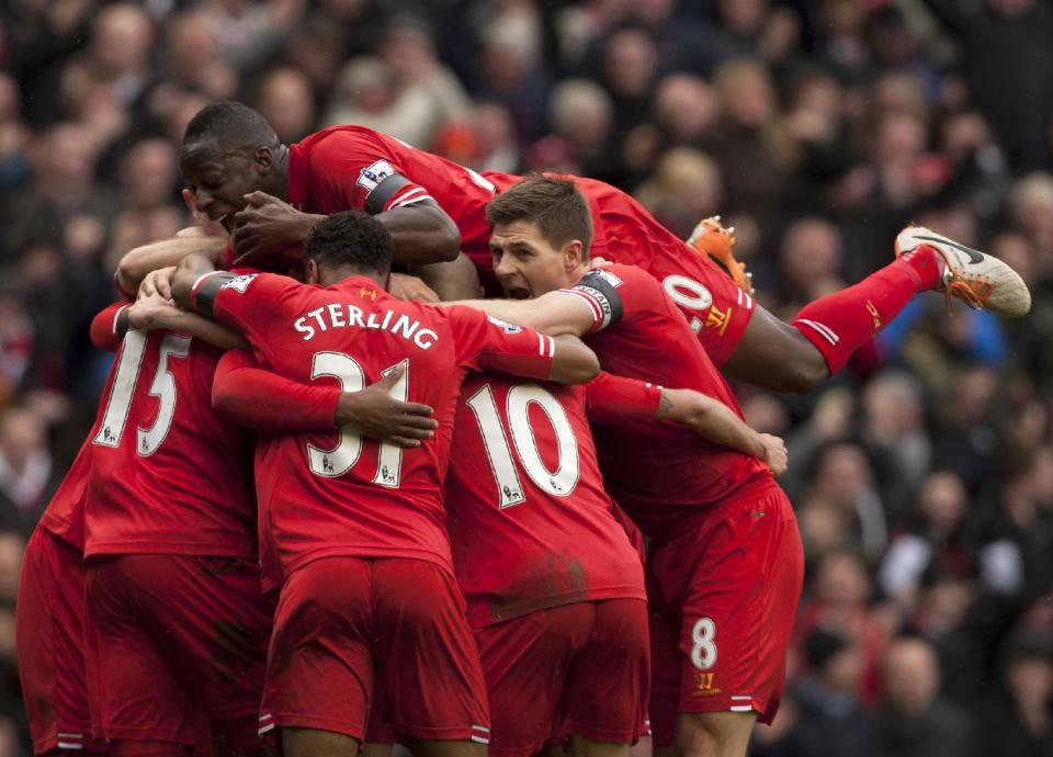 Liverpool's Daniel Sturridge, unseen, is swamped by jubilant teammates as he celebrates scoring his team's fourth goal against Arsenal during their English Premier League soccer match at Anfield Stadium, Liverpool, England, Saturday Feb. 8, 2014. (AP Photo/Jon Super)