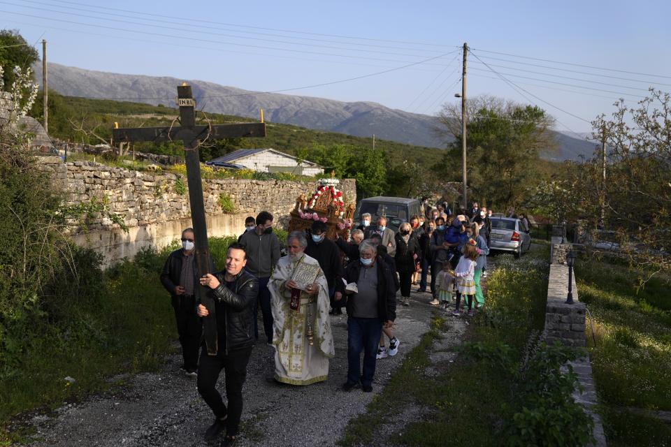 Faithful follow the procession of Jesus' funeral bier, known as the "Epitaph" in Greek, at Agios Georgios church in Myrodafni village, Epirus region, northwestern Greece, on Friday, April 22, 2022. For the first time in three years, Greeks were able to celebrate Orthodox Easter without the restrictions made necessary by the coronavirus pandemic. (AP Photo/Thanassis Stavrakis)