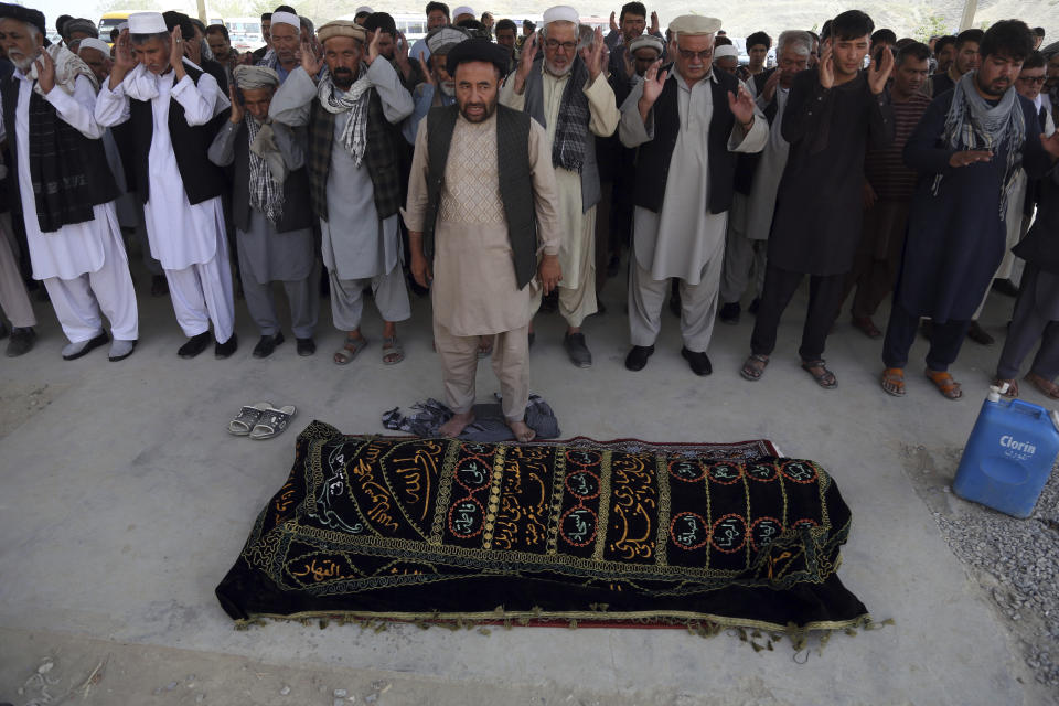 Afghan men offer funeral prayers beside the body of civilian killed in Wednesday's deadly suicide bombing that targeted a training class in a private building in the Shiite neighborhood of Dasht-i Barcha, in western Kabul, Afghanistan, Thursday, Aug. 16, 2018. The Afghan authorities have revised the death toll from the previous day's horrific suicide bombing in a Shiite area of Kabul to 34 killed. (AP Photo/Rahmat Gul)