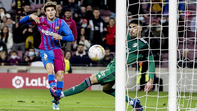 Gelandang Barcelona, Riqui Puig saat mencetak gol ke gawang Osusana pada pertandingan lanjutan La Liga Spanyol di di stadion Camp Nou di Barcelona, Senin (14/3/2022). Barcelona menang telak atas Osasuna 4-0. (AP Photo/Joan Monfort)