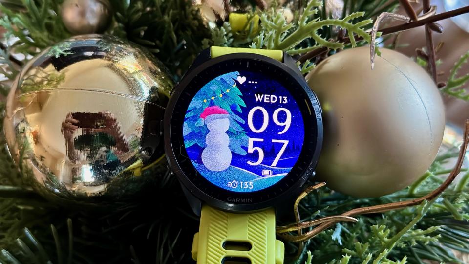 The Garmin Forerunner 965 with a festive watch face showing a half-built snowman