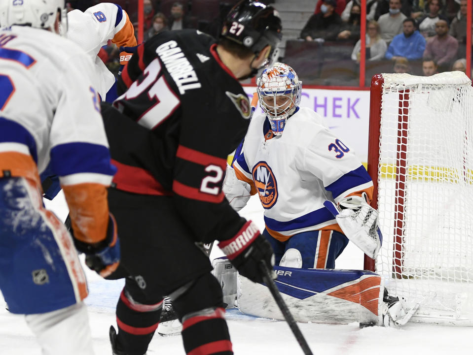 New York Islanders goaltender Ilya Sorokin (30) uses his pad to keep the puck out of his net as Ottawa Senators centre Dylan Gambrell (27) looks on during the second period of an NHL hockey game Tuesday, Dec. 7, 2021, in Ottawa, Ontario. (Justin Tang/The Canadian Press via AP)