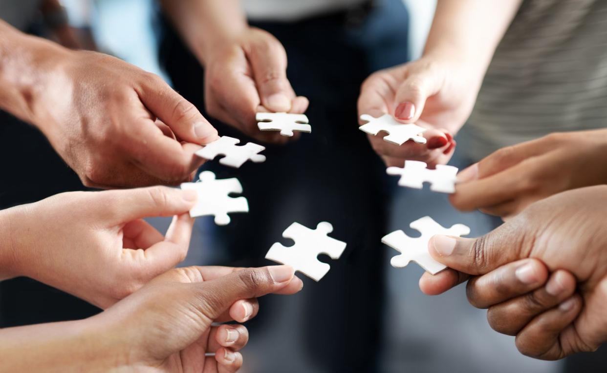 a group of business people holding puzzle pieces