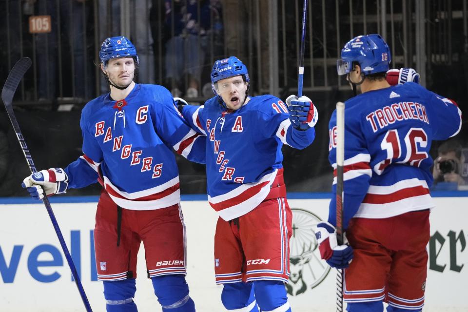 FILE - New York Rangers' Artemi Panarin (10), center, celebrates with teammates Jacob Trouba (8), left, and Vincent Trocheck (16) during the second period of an NHL hockey game against the Vancouver Canucks Monday, Jan. 8, 2024, in New York. Trouba is far more than a hockey player. In fact, the New York Rangers captain might be the most interesting man in the NHL. (AP Photo/Frank Franklin II, File)