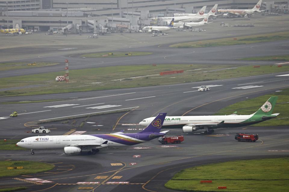 This aerial photo shows the airplanes of Thai Airways International, left, and Eva Airways, right, sit close on a runway, after the two passenger planes accidentally hit each other at Haneda airport in Tokyo, Saturday, June 10, 2023. (Kyodo News via AP)