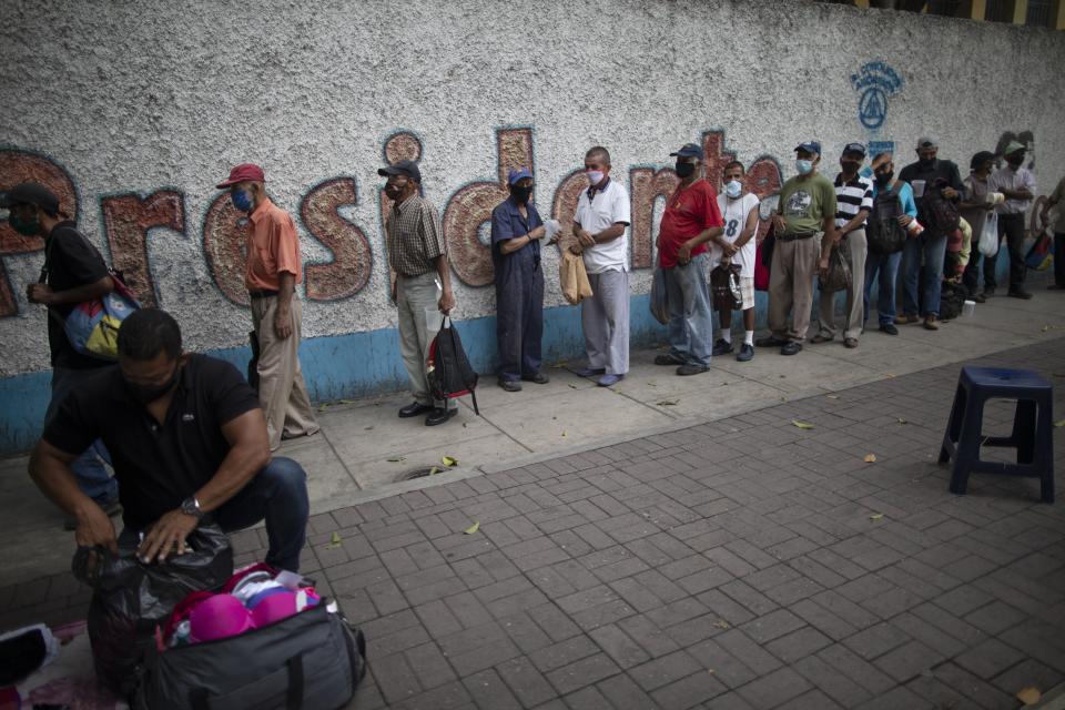 FILE - In this April 28, 2021 file photo, people stand in line outside a soup kitchen at the San Miguel Arcangel church in Caracas, Venezuela. A 2019 report from the U.N. Food and Agriculture Organization found that roughly a third of Venezuelans reported they had no food stored up and 11 percent reported sometimes going a day without food. (AP Photo/Ariana Cubillos, File)