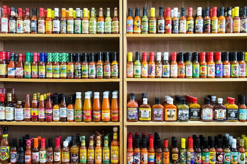 Bottles of hot sauce on a store shelf, showing various brands