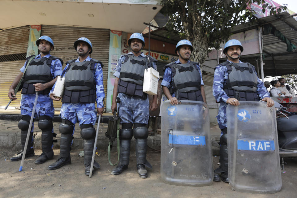 Security personnel stand guard on a street after violence erupted Thursday during a protest against the Citizenship Amendment Act in Ahmadabad, India, Friday, Dec. 20, 2019. Police banned public gatherings in parts of the Indian capital and other cities for a third day Friday and cut internet services to try to stop growing protests against a new citizenship law that have so far left eight people dead and more than 1,200 others detained. (AP Photo/Ajit Solanki)