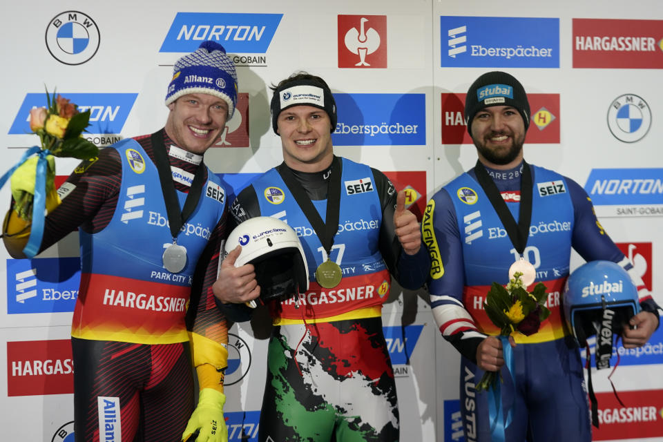 First-place finisher Italy's Dominik Fischnaller, center, shares the podium with second-place finisher Germany's Felix Loch, left, and third-place finisher David Gleirscher, right, of Austria, following the men's singles at a World Cup luge event Friday, Dec. 16, 2022, in Park City, Utah. (AP Photo/Rick Bowmer)