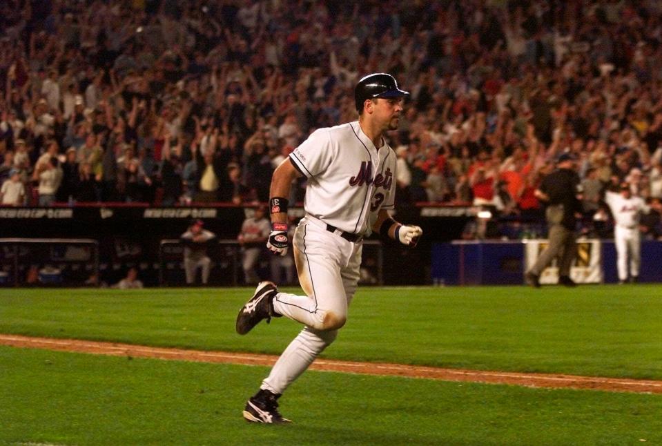 Shea Stadium erupts as Mike Piazza rounds the bases on his iconic two-run home run in the eighth inning against the Braves.