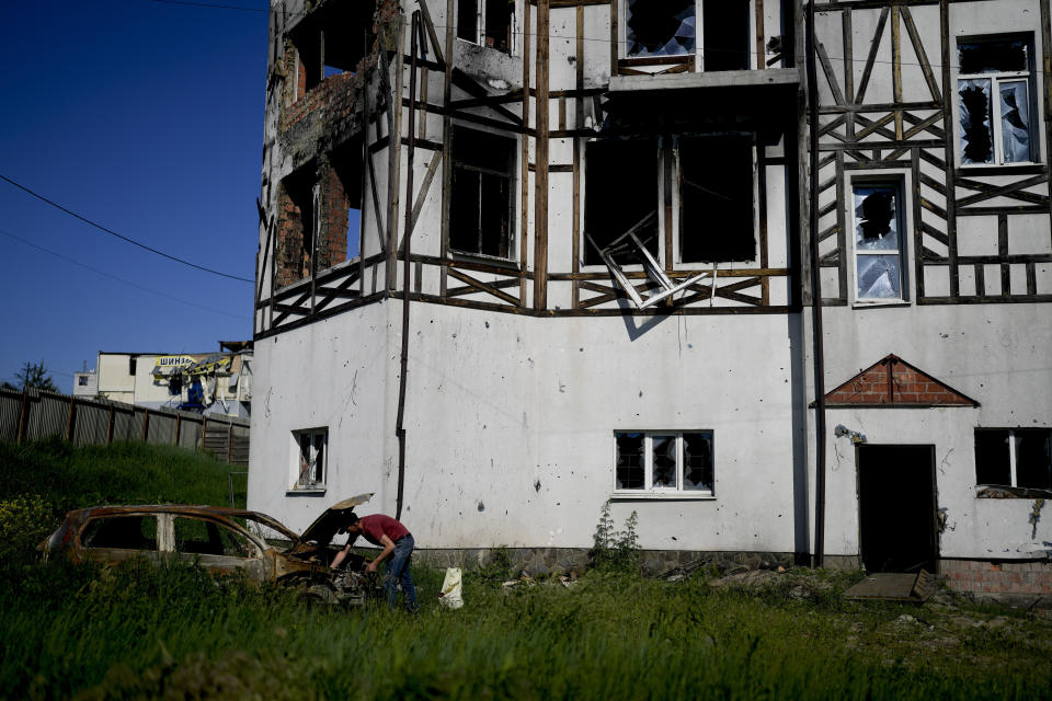 A man checks his car destroyed by attacks in Mostyshche, on the outskirts of Kyiv, Ukraine, Monday, June 6, 2022. (AP Photo/Natacha Pisarenko)