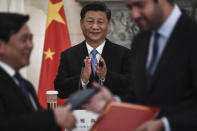 China's President Xi Jinping, centre, looks on as Greek and China's representatives exchange copies of agreements following a signing ceremony, after a joint news conference with Greece's Prime Minister Kyriakos Mitsotakis, at Maximos Mansion in Athens, Monday, Nov. 11, 2019. Xi Jinping is in Greece on a two-day official visit. (Aris Messinis/Pool via AP)