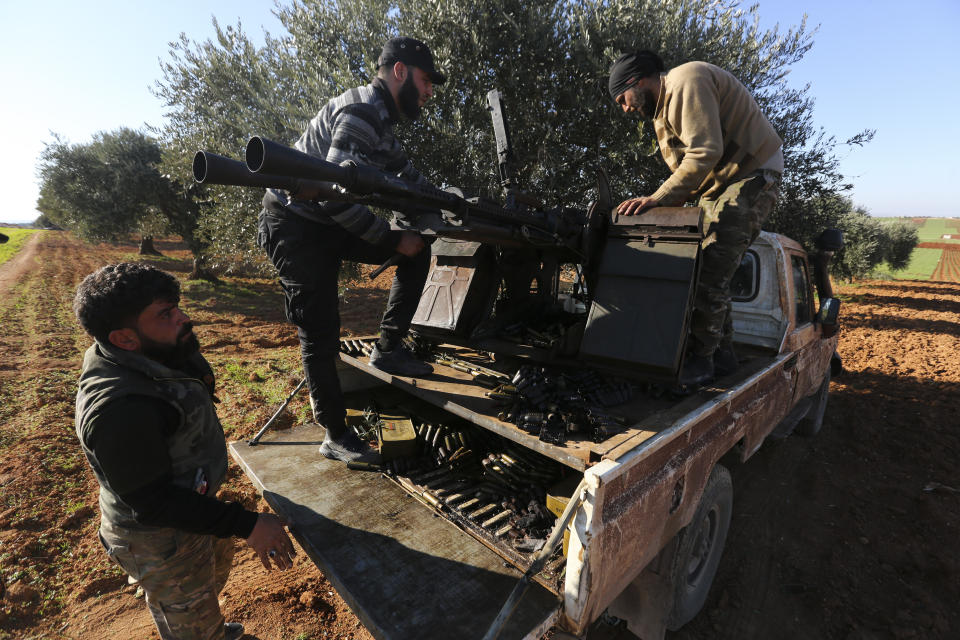 FILE - In this Wednesday, Feb. 26, 2020 file photo, Turkish backed Syrian fighters load ammunition at a frontline near the town of Saraqib in Idlib province, Syria. Syria’s official news agency said Sunday, March 1, 2020, that two of its warplane were shot down by Turkish forces inside northwest Syria, amid a military escalation there that's led to growing direct clashes between Turkish and Syrian forces. SANA said the jets were targeted over the Idlib region, and that the four pilots ejected with parachutes and landed safely. (AP Photo/Ghaith Alsayed, File)