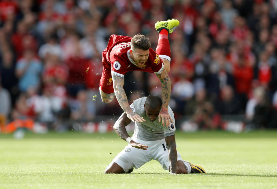 <p>Liverpool’s Alberto Moreno goes flying over Ashley Young</p>