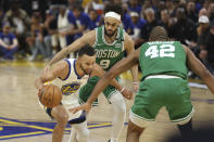 Golden State Warriors guard Stephen Curry (30) is defended by Boston Celtics center Al Horford (42) and guard Derrick White (9) during the first half of Game 1 of basketball's NBA Finals in San Francisco, Thursday, June 2, 2022. (AP Photo/Jed Jacobsohn)