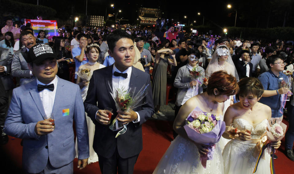 Taiwanese same-sex couples walk thered carpet at their wedding party in Taipei, Taiwan, Saturday, May 25, 2019. Taiwan became the first place in Asia to allow same-sex marriage last week. Hundreds of same-sex couples in Taiwan rushed to get married Friday, the first day a landmark decision that legalized same-sex marriage took effect. (AP Photo/Chiang Ying-ying)