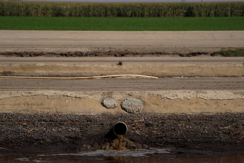 Waste water pours into a collecting pond in Pixley, California