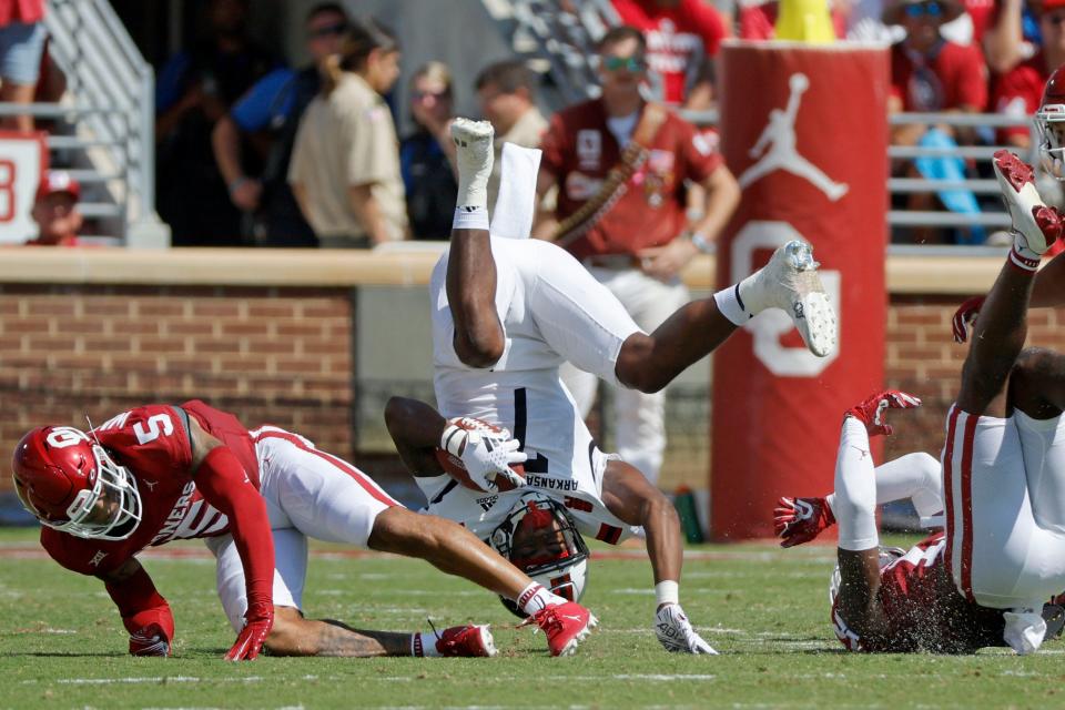 OU's Woodi Washington (5) and Key Lawrence (12) bring down Arkansas State's Corey Rucker (7) during the Sooners' 73-0 win last Saturday in Norman.